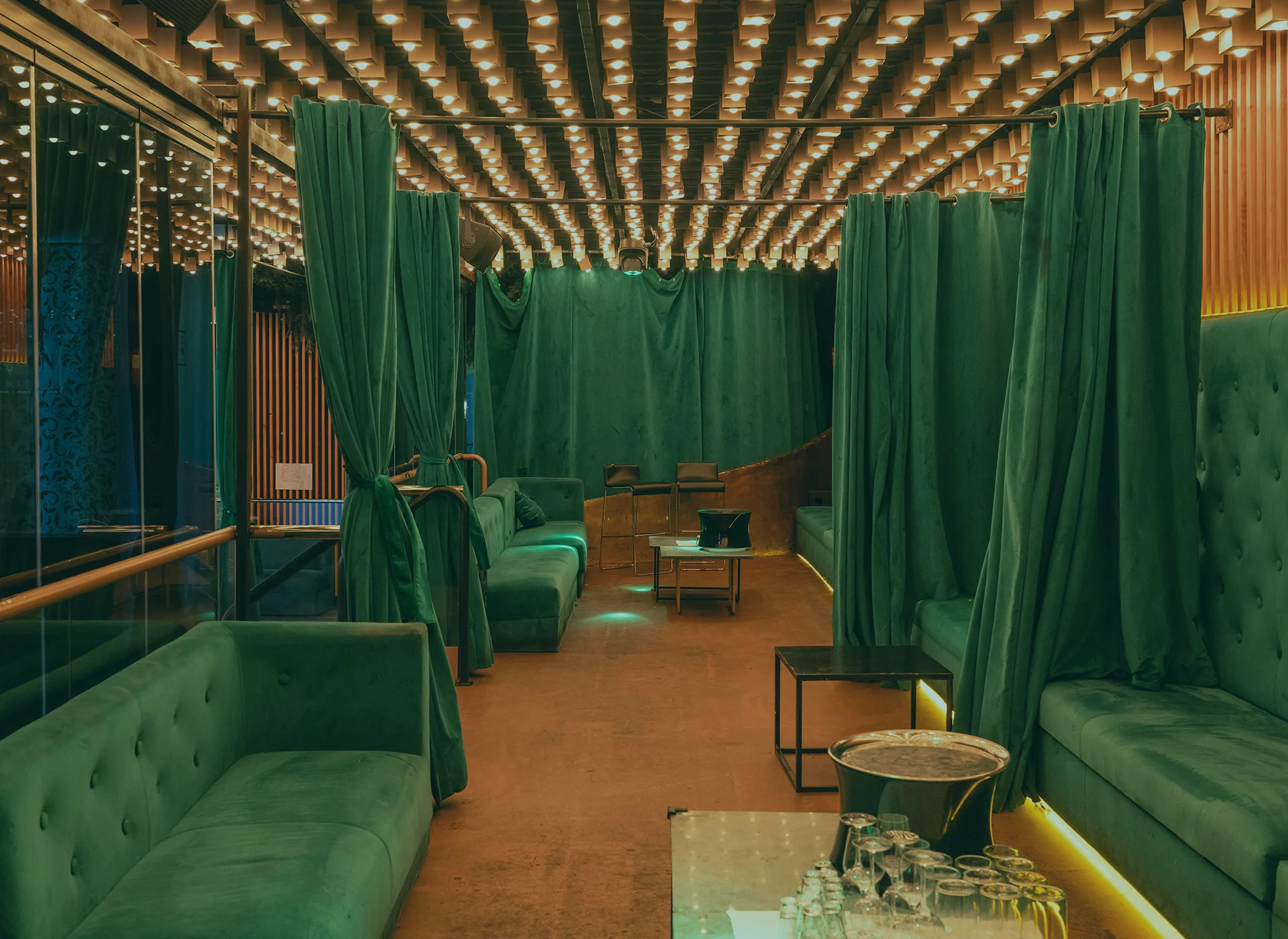 Garden room with VIP booths behind green curtains at Oh My Club Madrid