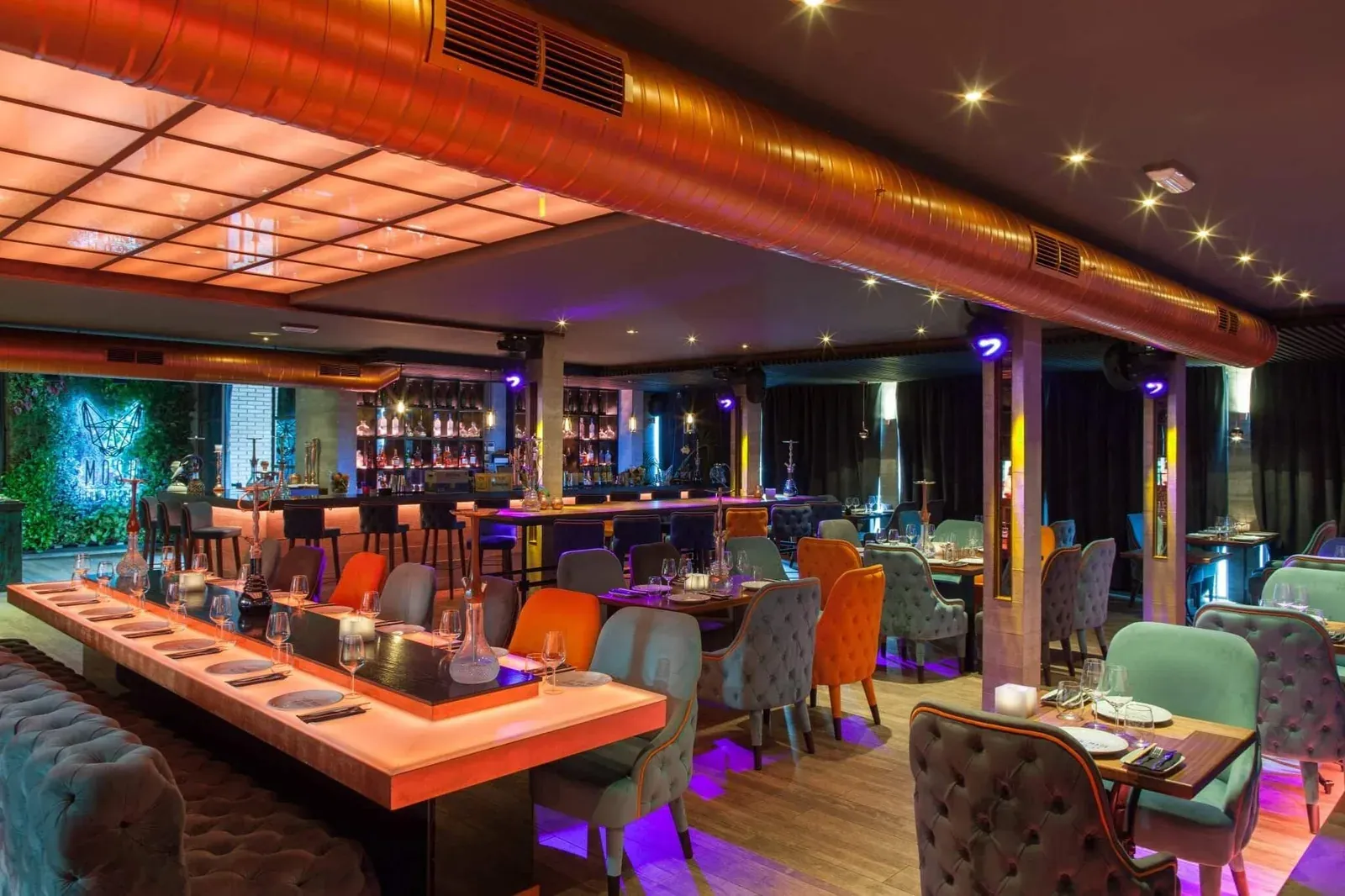 Zaal met logo en gedekte tafel bij Mosh Fun Kitchen Marbella